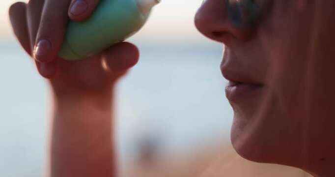 Close-up of woman vaping at sunset