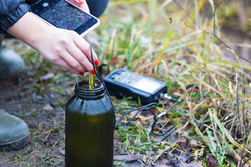 Scientist ecologist with equipment testing water samples. Field research of water samples in field. Ecology and environmental protection concept.