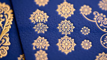 Letterpress-style debossed gold patterns on cobalt paper texture, tactile design element