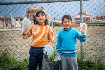 two latin kids waving happily after cleaning the streets of garbage for recycling in latino...
