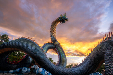 Phaya Si Mukda Maha Muni Nilapala Nakkharat The King of giant Naga statue at Wat Phu Manorom in sunset ,Mukdahan Province Thailand.
