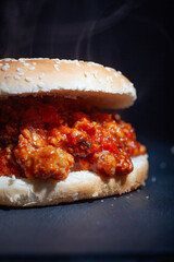 Sloppy Joe sandwich on dark background.