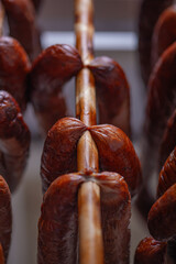 Pork sausages are being dried after smoking.