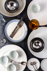 Top view of an empty plates, bowls, glasses and cutlery placed on a black chalkboard background. Flat lay. Top view. Food concept.