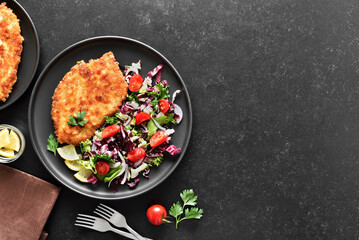Chicken schnitzel and vegetable salad on plate