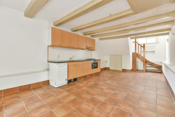 A bright and spacious kitchen featuring wooden beams, tiled flooring, and modern cabinetry. Ideal...
