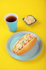 Imitatiom crab meat mayonnaise salad sandwich in a plate on a yellow background