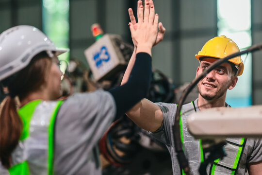 Industrial Engineer and Technician Inspecting Robotic Arm Machinery.