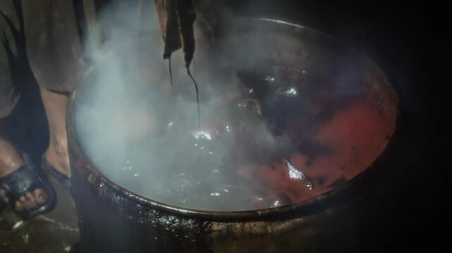 Boiling batik with hot water and soda ash to clean the wax that is still stuck. The traditional process of making indonesian batik