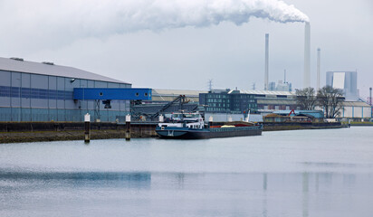 General cargo ship during loading and unloading with loading equipment and warehouses at the...