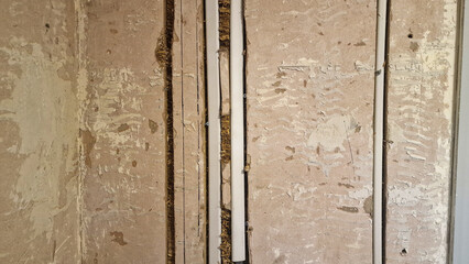 Close up of electrical wires being installed in a plaster wall