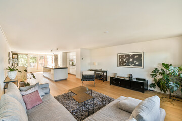 Spacious living room featuring contemporary furniture, lush greenery, and abundant natural light, creating a serene and inviting atmosphere.
