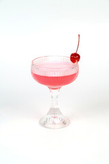 A refreshing red cocktail with cherries and strawberries. Served in a martini glass. With ice and white liquid Isolated on blue background for sweet and fruit drinks.
