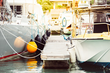 Boats moored at marina with floating dock and ropes, summer travel destination