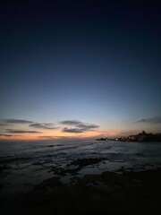 Fototapeta premium Vibrant sunset illuminating coastal landscape near Santa Croce Camerina, painting Sicilian sky with warm gradient hues