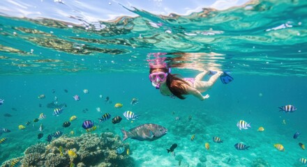 Snorkeler with fish in turquoise ocean, photo