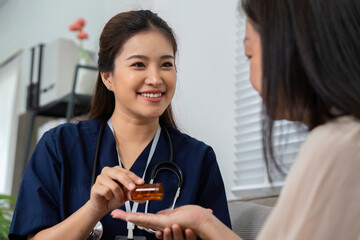 Patient Interaction and Caregiver Support. A caregiver smiling while handing a medication bottle to a senior woman.