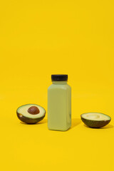 Plastic bottle of fresh vegan smoothie on yellow minimal background. Wellness and healthy eating concept