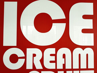 Bold white "ICE CREAM" text on a vibrant red background. Eye-catching signage for a dessert or treat business.