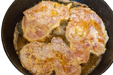 The cooking process in a pan of fried chop in batter.