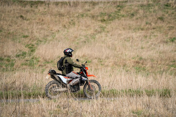 motor cyclist (biker) riding their off-road motorbike through countryside