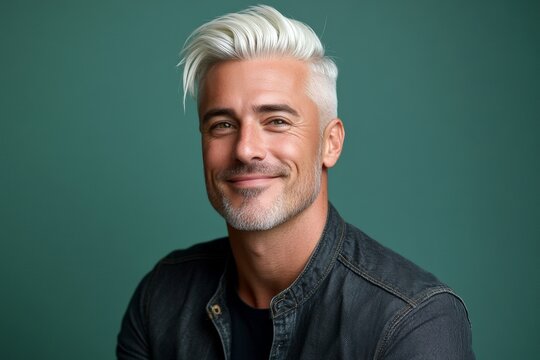 A confident and poised man in a professional setting. Visual idea of style for aging men. Green solid background. Chic men's slick back with fade haircut - midlife white man with white hair.