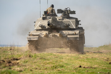 Fototapeta premium close-up of a commander directing a Challenger 2 II FV4034 main battle tank, reversing away at high speed