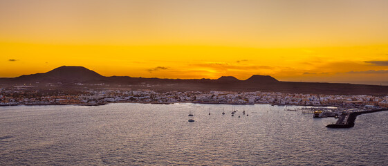 Spectacular aerial panoramic landscape image of the evening sunset sky at golden hour over the town of Corralejo, Fuerteventura, Canary Islands, Spain