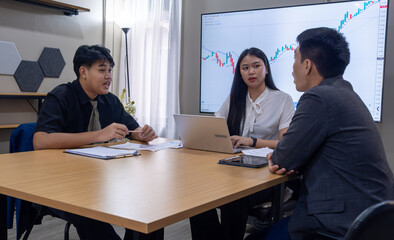 Fototapeta premium Professionals discuss financial strategies in modern office during business meeting