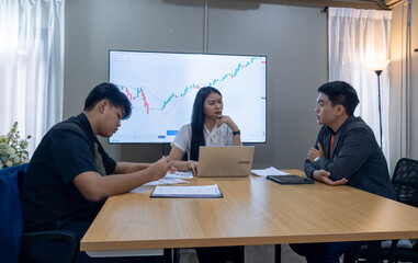 Fototapeta premium Team discusses market analysis in modern office setting during business meeting focused on investment strategies