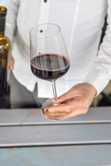 Glass of red wine in hands. Selective focus.
