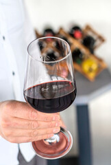 Glass of red wine in hands. Selective focus.