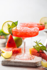 Watermelon frozen cocktail margarita with fresh watermelon, lime and mint on white background