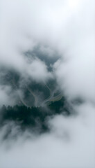 Naklejka premium view of a mountain covered in clouds