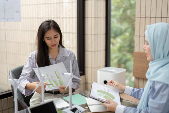 Data Analysis and Sustainable Design. A woman reviewing graphs and models for a green project in a collaborative setting.