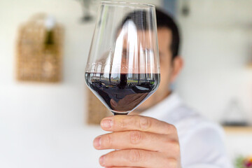 Glass of red wine in hands. Selective focus.