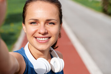 close-up self-portrait of fit woman runner on run track in city.