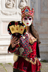 Venice, Italy - People dressed in carnival masks are photographed by tourists in the scenery of the ancient Venetian palaces