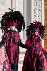 Venice, Italy - People dressed in carnival masks are photographed by tourists in the scenery of the ancient Venetian palaces