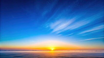 Obraz premium A serene and vast clear blue sky with no clouds visible above the horizon at sunrise