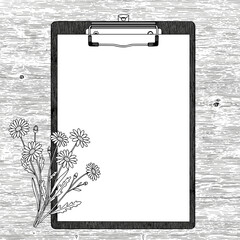 A blank sheet of paper with flowers on a rustic wooden background
