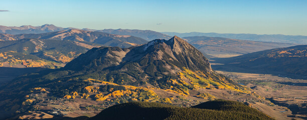 Mt Crested Butte (12,162') standing as an island in the Elk Range mountains of Colorado adorned by vibrant aspen trees.