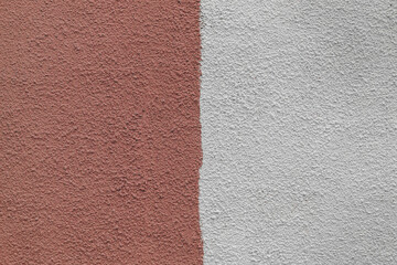 Fototapeta premium A wall with a red and white stripe. The red is darker than the white. The wall is made of concrete.