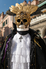 Venice, Italy - People dressed in carnival masks are photographed by tourists in the scenery of the ancient Venetian palaces