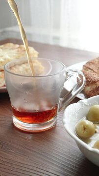 Local Turkish breakfast table Turkish tea, su boregi, green olives and simit bagel	