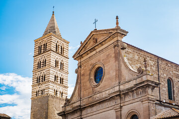San Lorenzo Cathedral in Viterbo, Italy, features striking Romanesque and Gothic architecture with a striped bell tower set against a clear blue sky