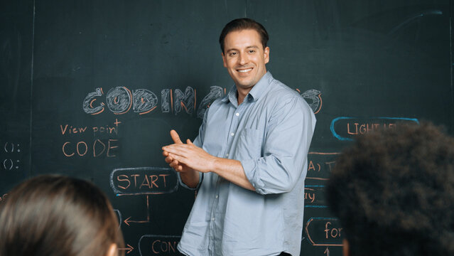 Professional happy teacher answering student question about coding program while standing at blackboard. Caucasian girl learning programing system while attend in STEM technology class. Edification. - Powered by Adobe