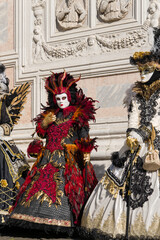 Venice, Italy - People dressed in carnival masks are photographed by tourists in the scenery of the ancient Venetian palaces