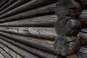 Perspective view of the wall of a log house. Log wall of an old house, close-up. Perspective view of parallel logs, macro.
