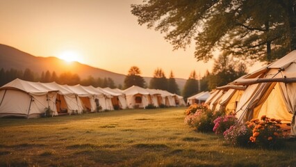 Obraz premium A tranquil glamping site at sunset, featuring spacious tents arranged along a gravel path